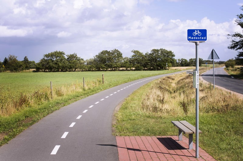 Dobbeltrettet cykelsti, der løber parallelt med en lille tosporet vej