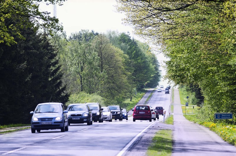 Foto af vej med biler og enkeltrettede cykelstier i begge sider